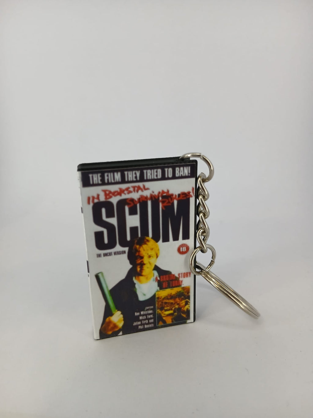 Scum VHS keyring — back and spine angled view standing