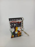 Scum VHS keyring — back and spine angled view standing