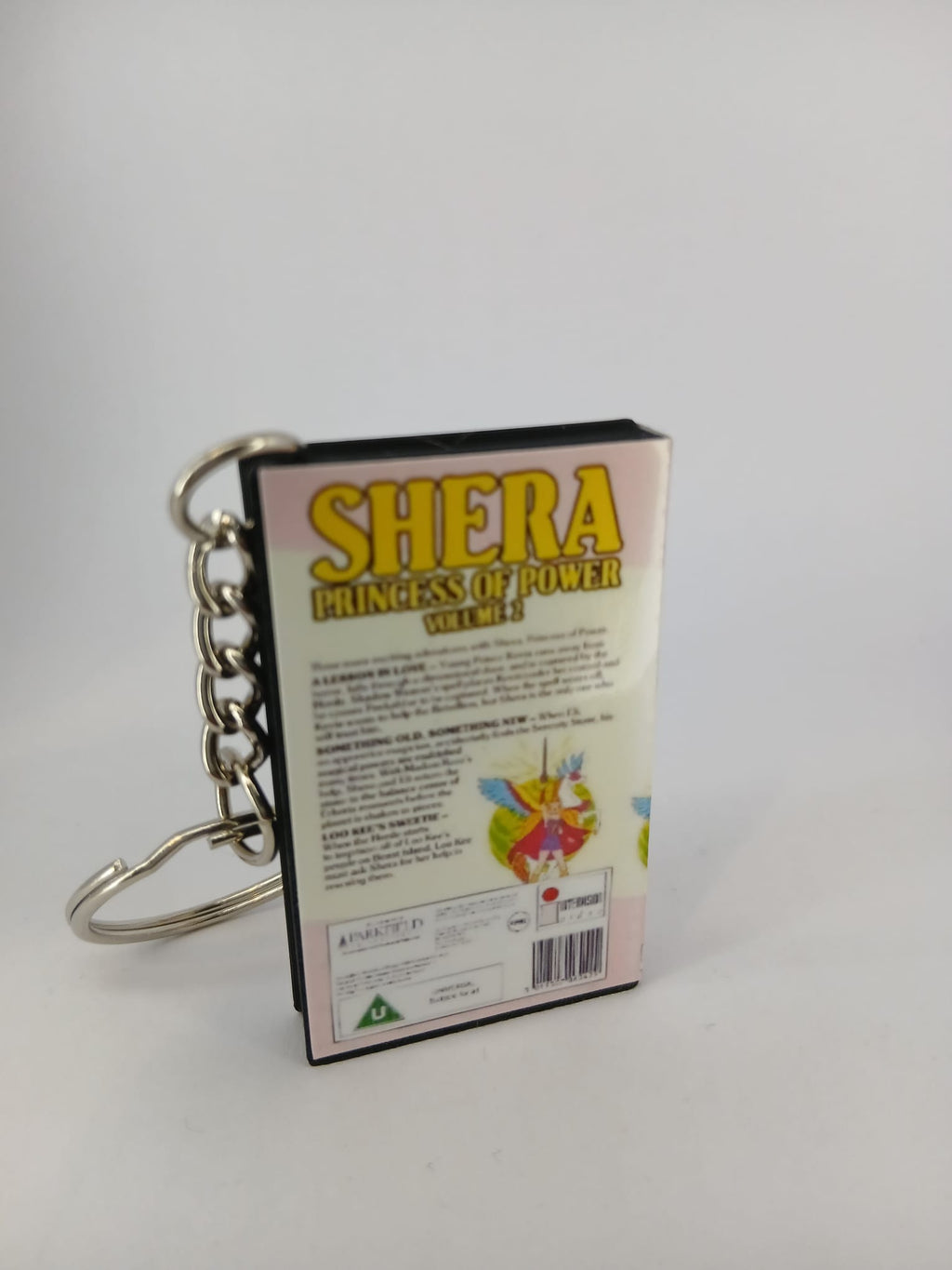 She-Ra Princess of Power VHS keyring — flat lay front and spine angled