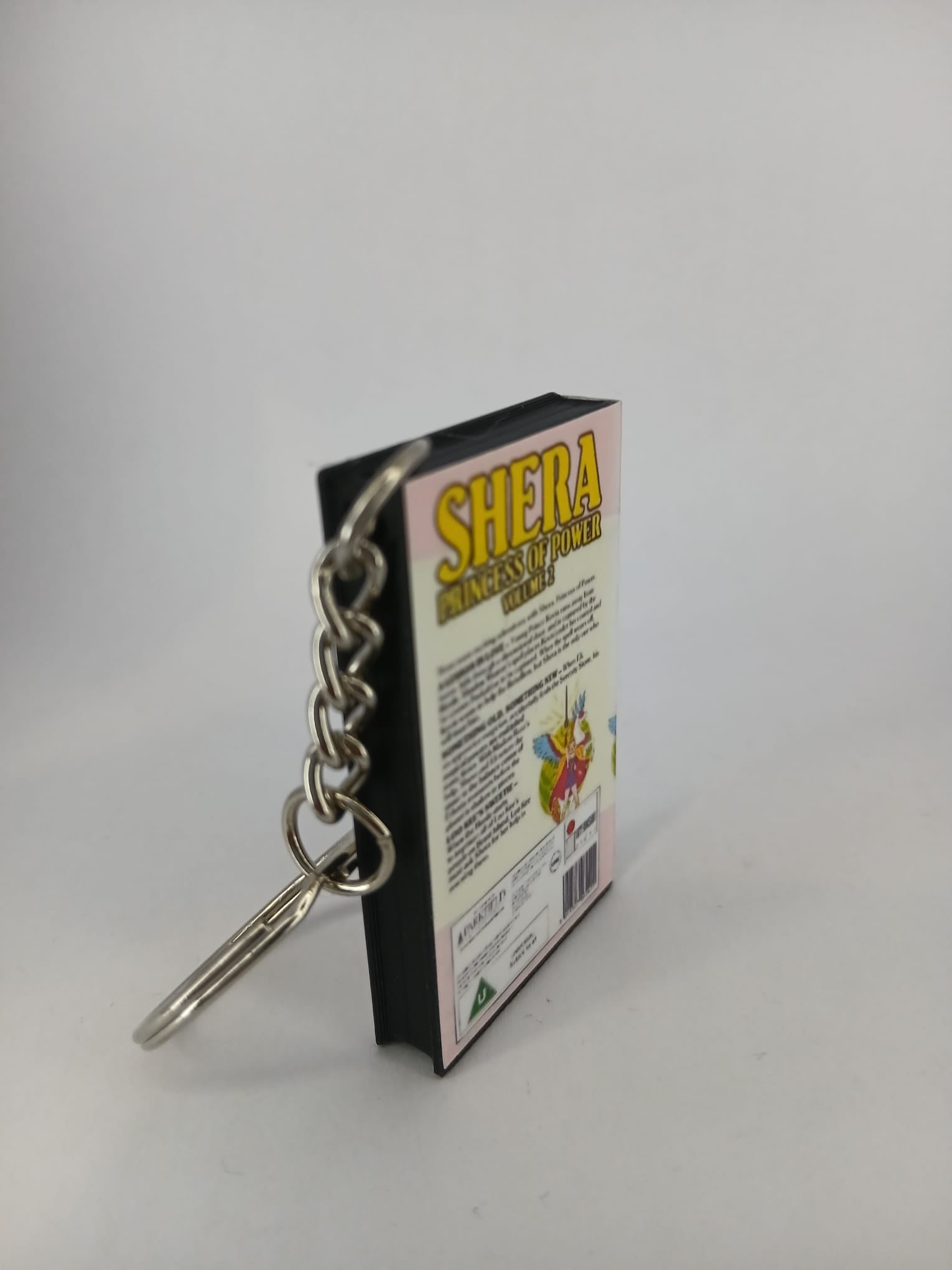 She-Ra Princess of Power VHS keyring — flat lay back and spine angled
