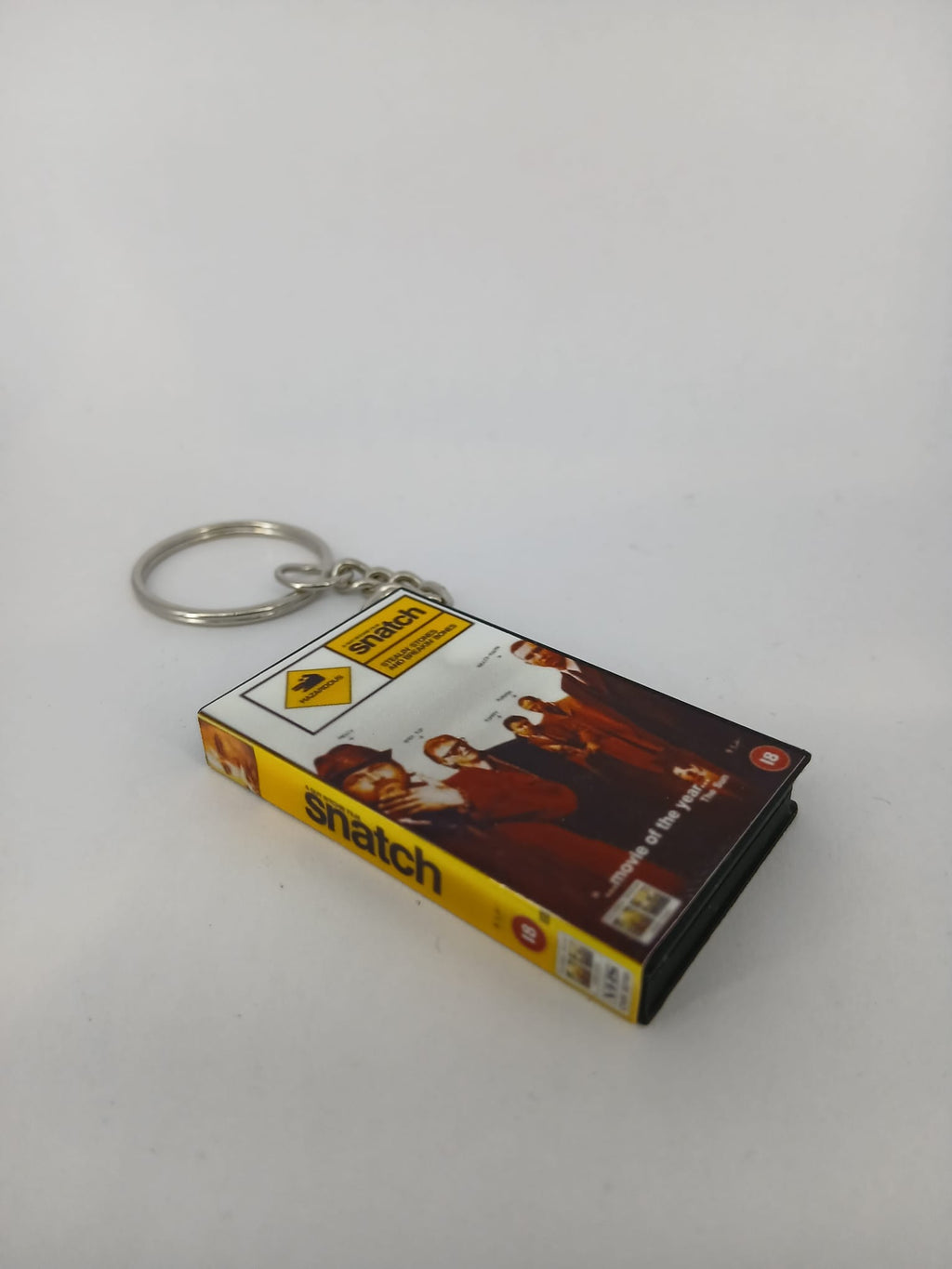 Snatch VHS keyring — back cover angled view standing