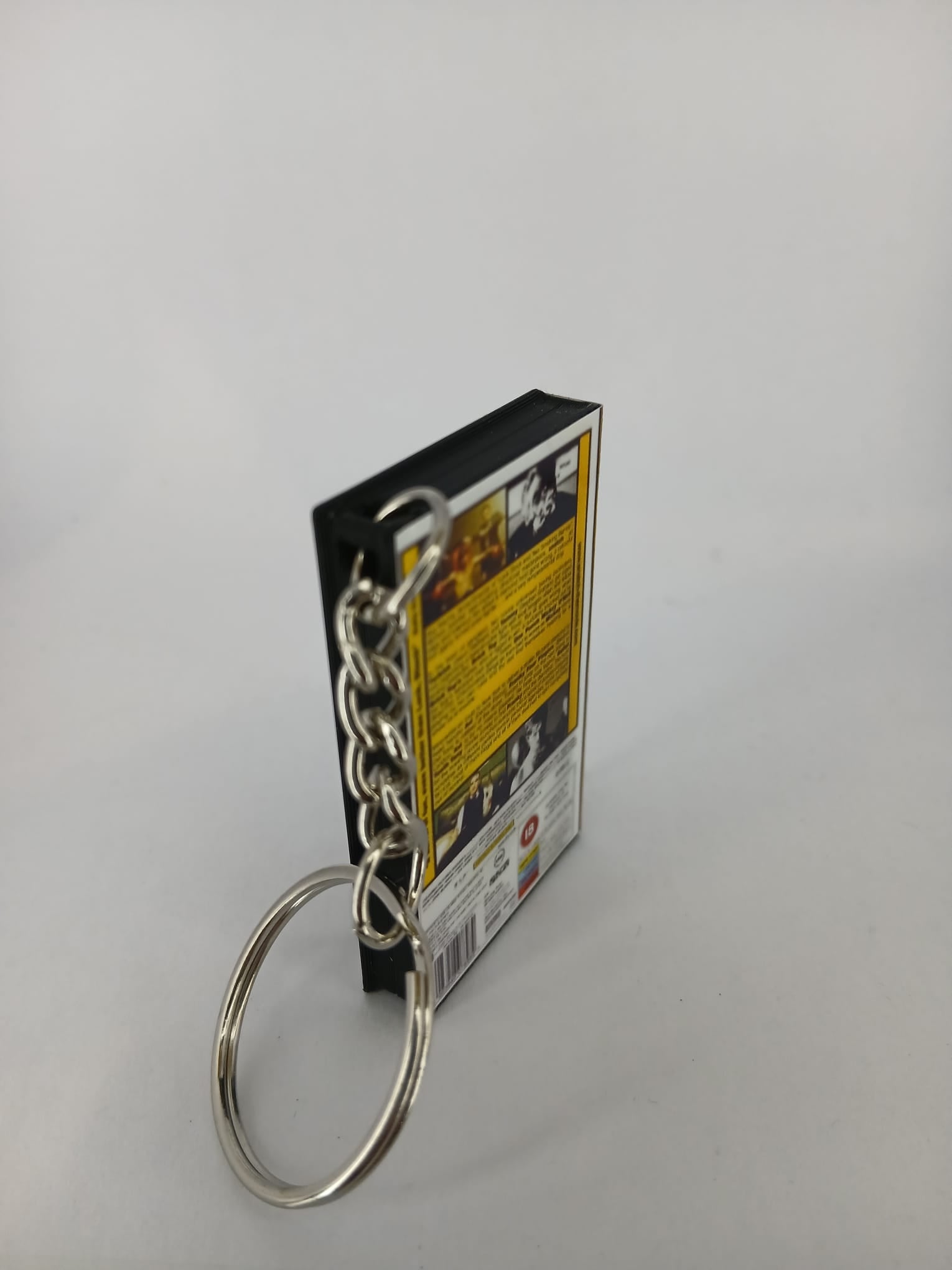 Snatch VHS keyring — front and spine angled view standing