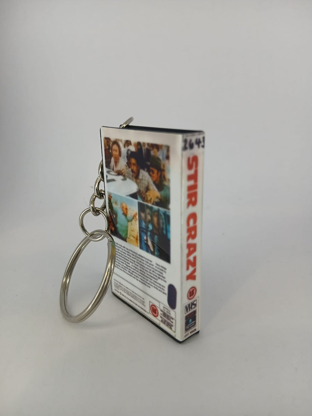 Stir Crazy VHS keyring — front cover standing angled