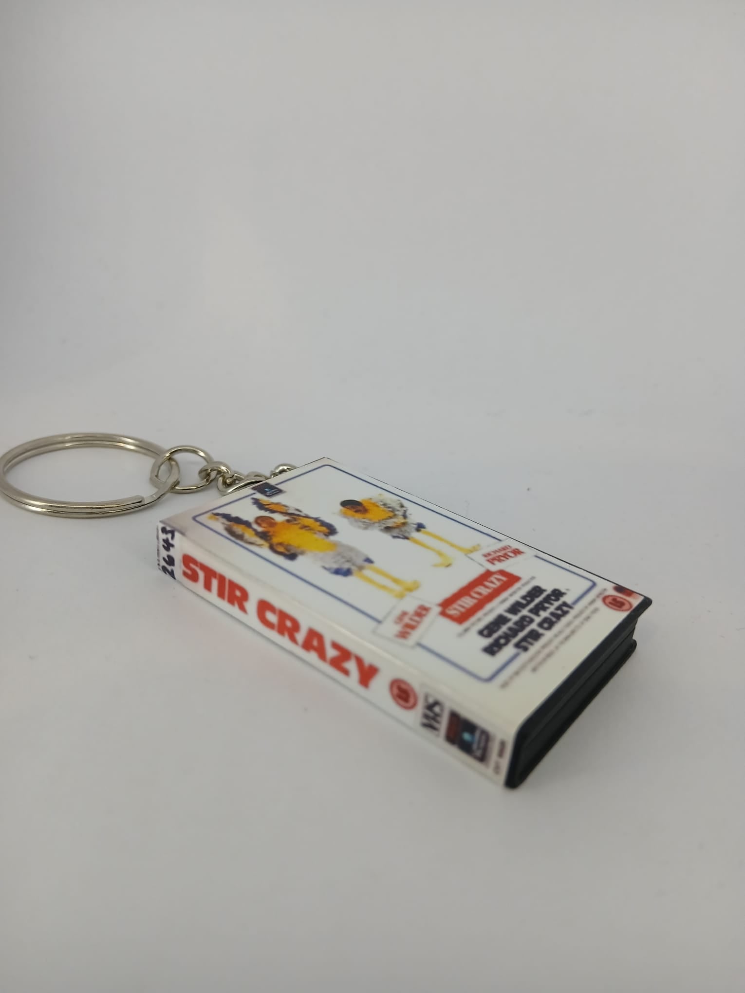 Stir Crazy VHS keyring — front cover standing angled 2